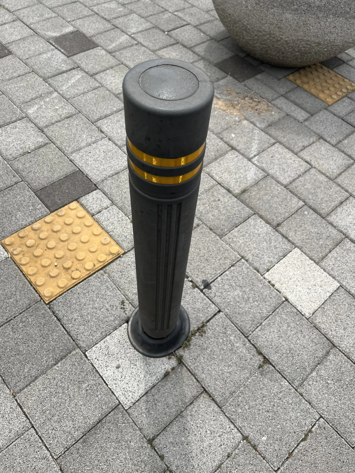 보도 경계에 설치된 반사 슬리브형 원형주차봉 클로즈업